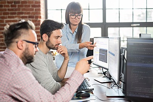 Group of employees looking at monitor 