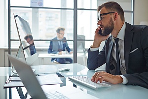 Tech worker on phone at computer 